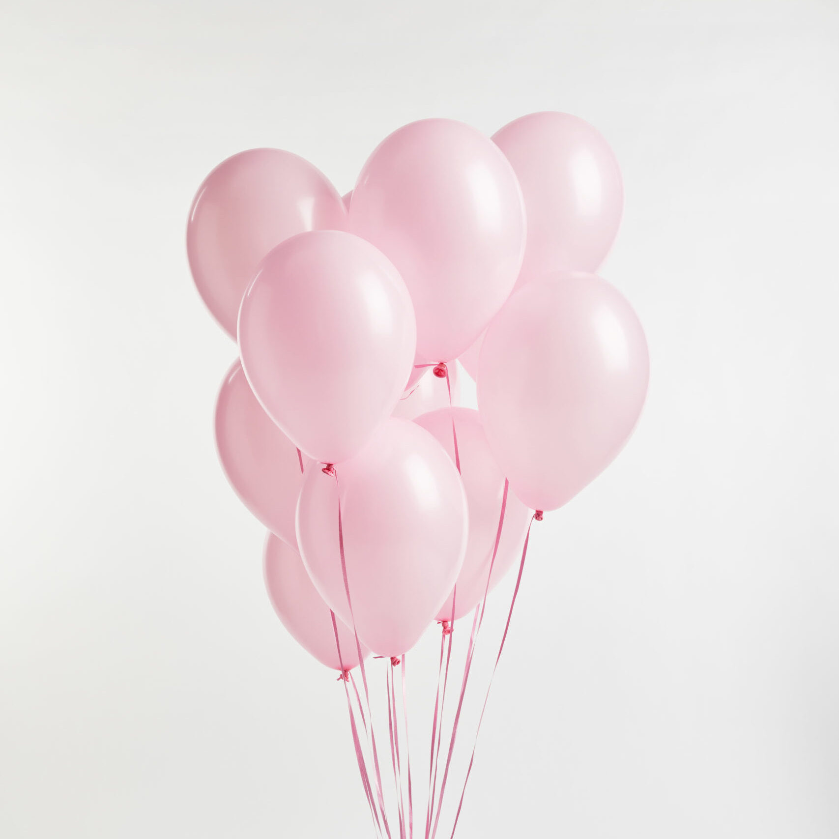 bundle of pink festive air balloons with turquoise gift box on white